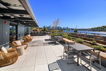 a patio with tables and chairs and a view of the city